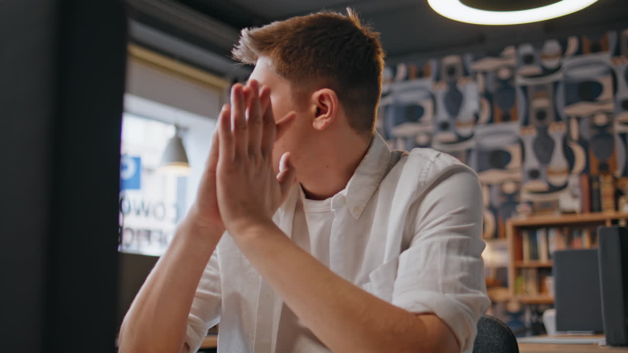 Pensive developer working laptop at desk closeup. Tired man closing computer