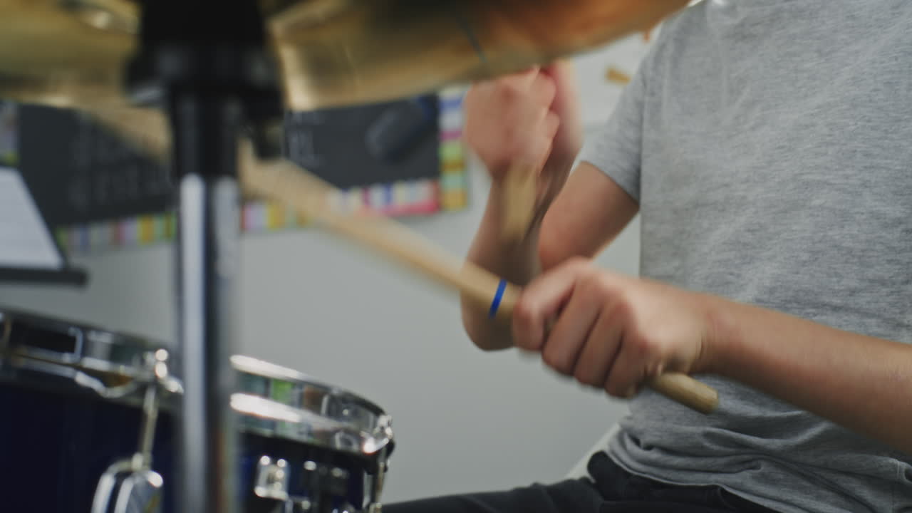 Close Up Shot of Primary School Boy Practicing Drums in Music Class Dreaming to Become Drummer