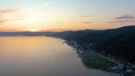 sunrise over a lake town with mountains