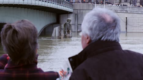 ots of couple observing flooded zouave statue