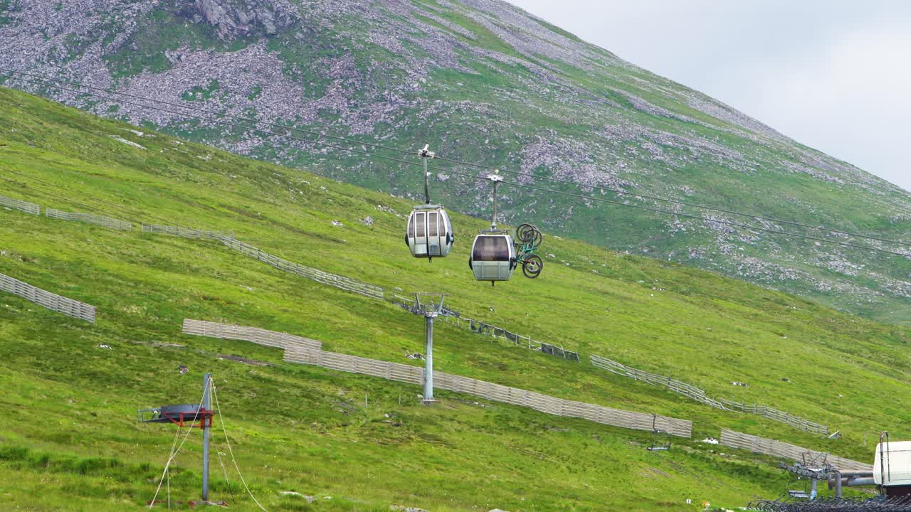 스코틀랜드에서 오작동이 발생한 후 케이블카가 다시 운행을 시작하기를 기다리는 두 대의 산악 자전거가 있는 고정식 케이블카 트레이