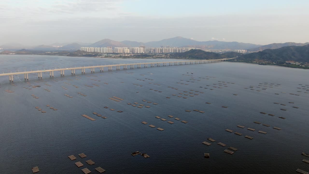 지평선에 틴수이와이 건물이 있는 홍콩 심천 베이 브리지와 어류 및 굴 양식장, 공중 전망