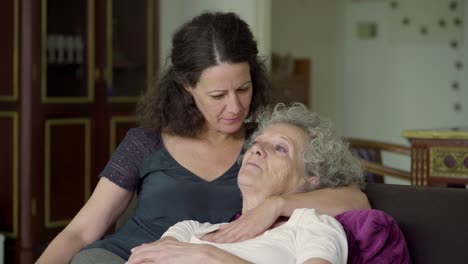 mother lying on daughters hands, talking, looking at each other