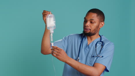 Male-nurse-holding-IV-bag,-preparing-to-use-it-to-administer-fluids