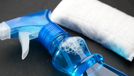 botella de aerosol y paño de limpieza en la mesa