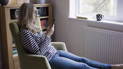 woman reading a cell phone in a chair