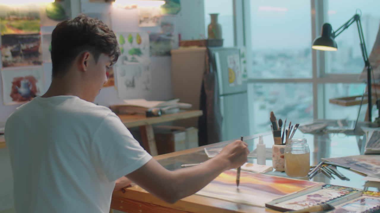 Artist Painting Picture at Desk in Workshop