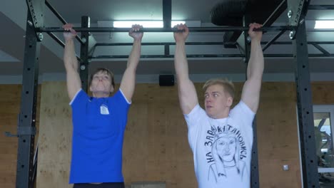 men doing pull-ups in a gym