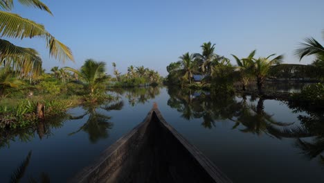 canoe passing in calm canal in kerala