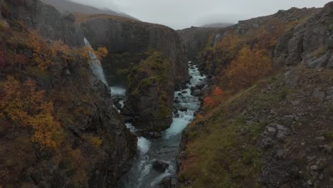 hidden waterfall in autumn colours in iceland