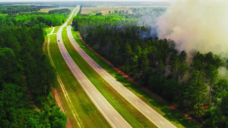 highway with forest fire smoke rising in georgia, usa