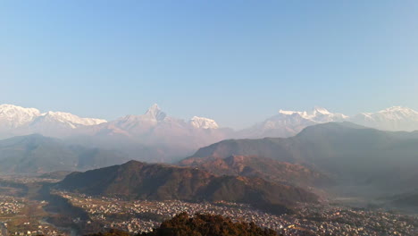 aerial: landscape with snowy peaks and the suburbs of pokhara. sunrise in nepal
