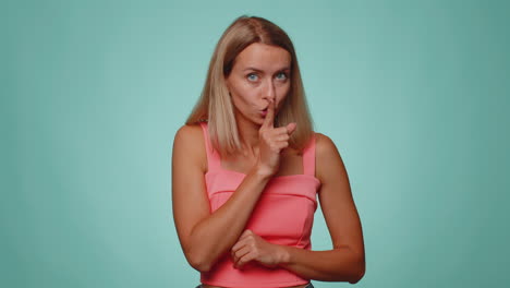 Young-woman-presses-index-finger-to-lips-makes-silence-gesture-sign-do-not-tells-secret-shh-be-quiet