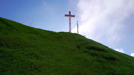 drone disparó a jesús cristo cruz cristiano en las verdes colinas de nepal con nubes, sol, hermosa naturaleza, colinas, paisaje, banderas budistas, entorno celestial paz y calma 4k