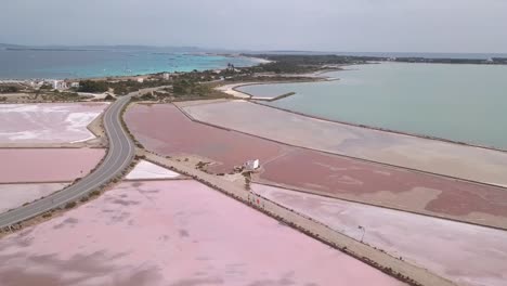 smooth zoom in on the beautiful island of formentera about four men running between the salt flats. in the background the curious shapes of the island