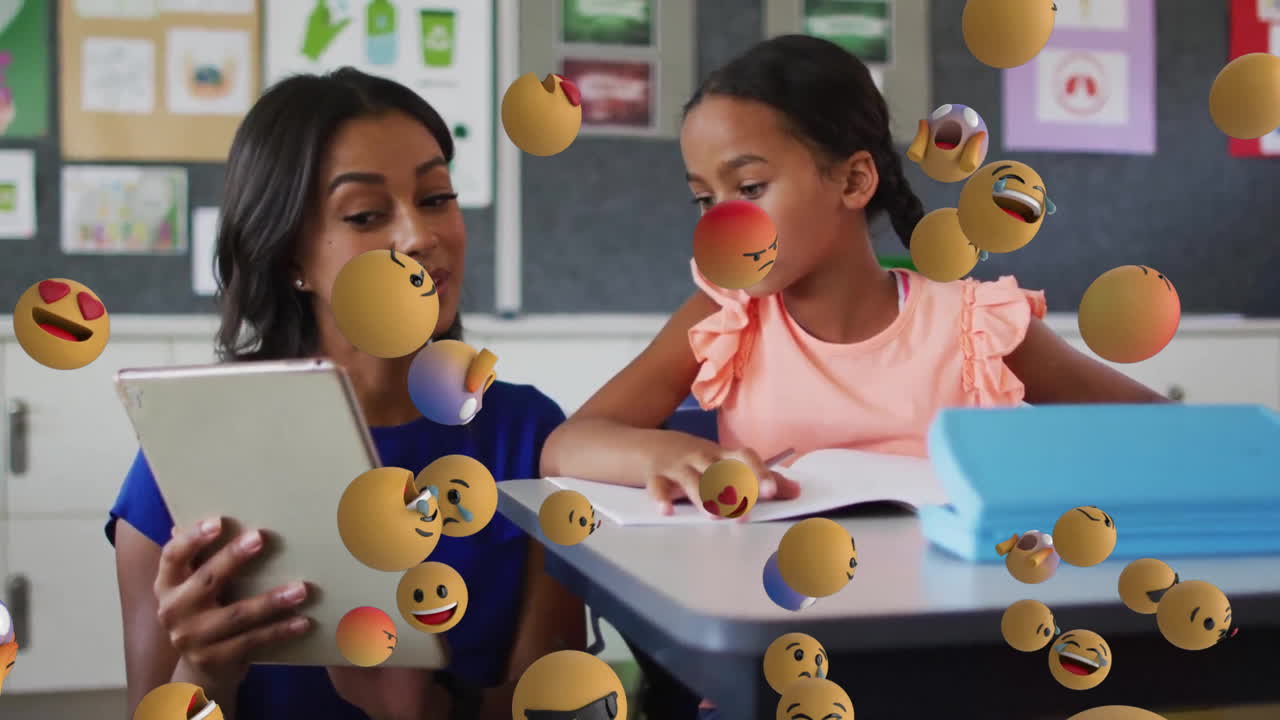 Animation of emoji icons over biracial schoolgirl and teacher using laptop