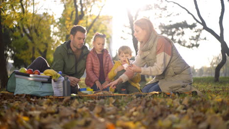 family enjoying a picnic in the park during autumn