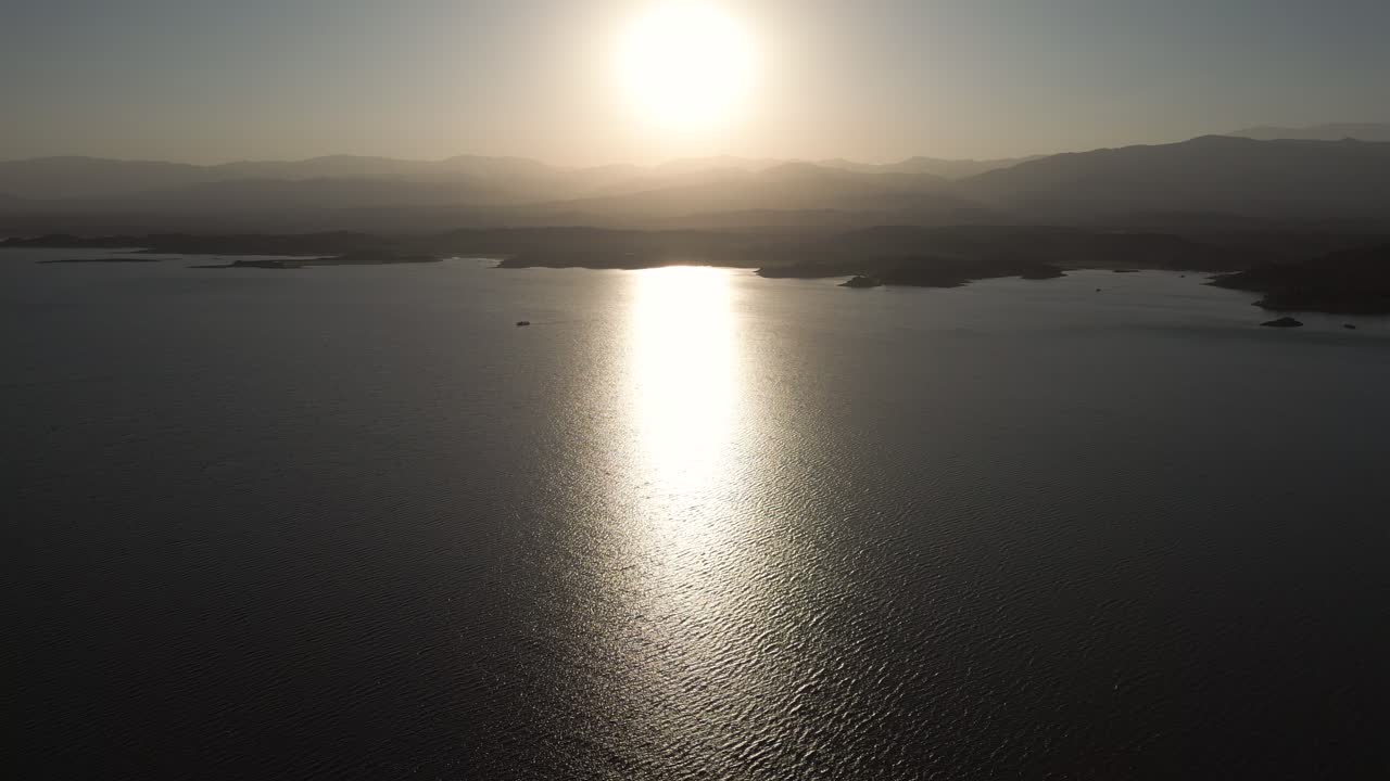 Golden Sun Reflection on Calm Lake Surface at Sunset