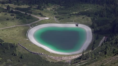 small local surface water reservoir filled with water near jochgrimm - passo occlini, trentino, italy