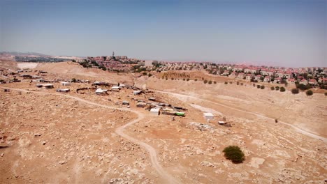 aerial view of informal desert settlements contrasted with a modern city