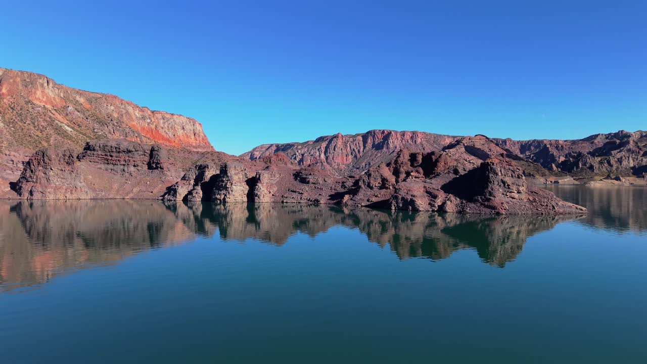 Valle Grande’s blue waters, revealing the jagged cliffs of Cañón del Atuel in San Rafael, Mendoza, Argentina, where wind-carved rock and desert silence meet alpine light, drone fast horizontal glide