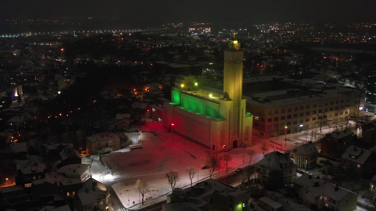Aerial view of Christ's Resurrection Church in a winter evening and under National Lithuania flag lighting. Lithuania.