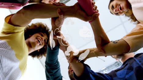 animation of globe with medical icons over diverse business people stacking hands