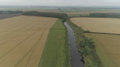 Aerial-shot-flying-above-the-River-Forth-and-farmland-in-the-Stirlingshire-countryside-on-a-overcast-day