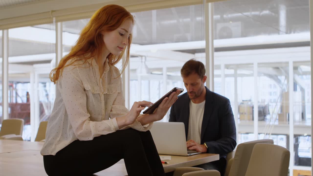 Forretningskolleger bruger tablet og bærbar computer 4K