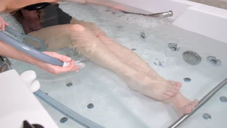 a woman enjoying a hydromassage in a jacuzzi. a relaxed woman receives a hydromassage from a professional beautician in a spa center.