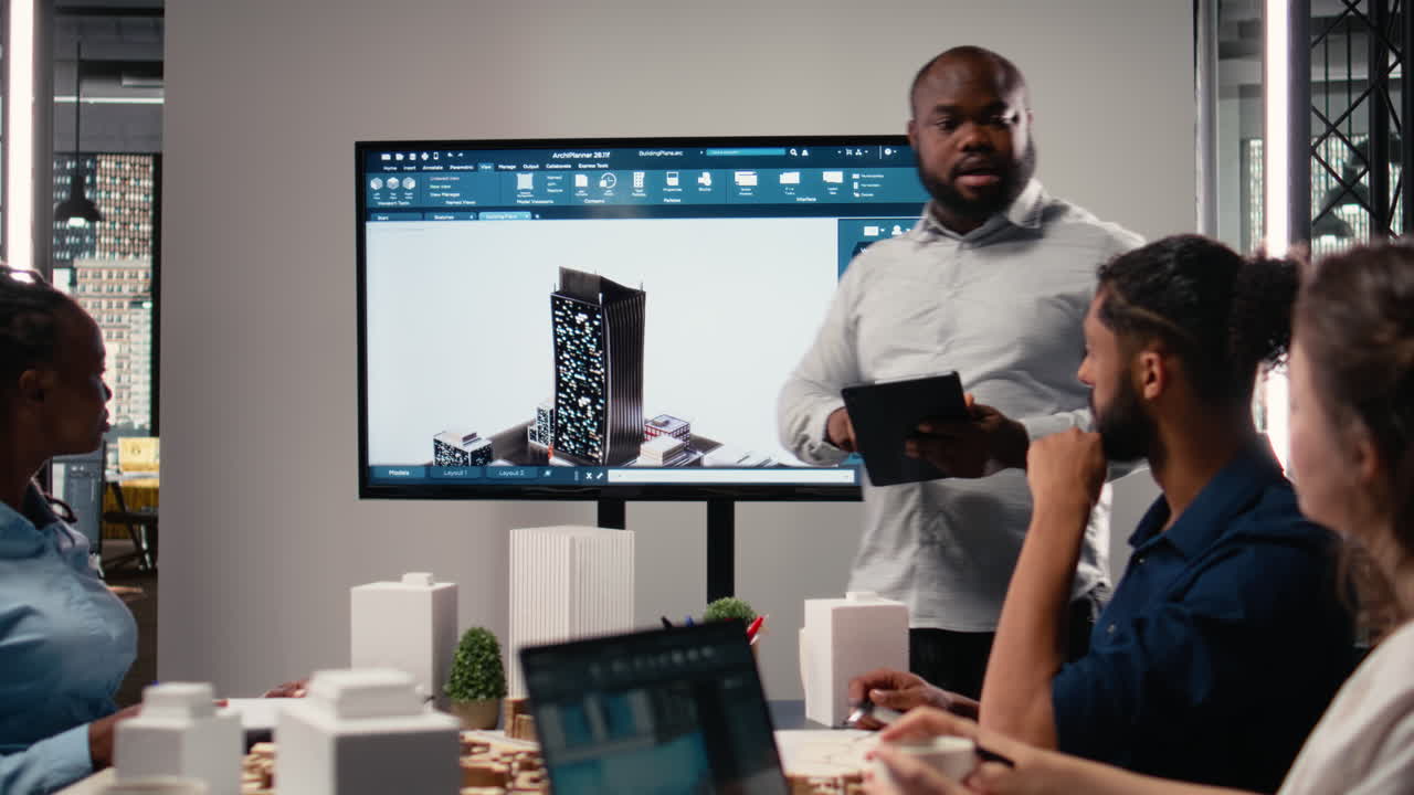 Black contractor reviewing architectural software and 3D models with his team