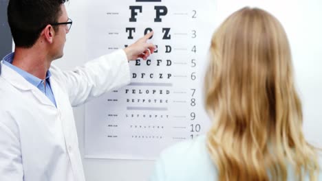 optometrist taking eye test of female patient