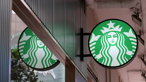 the recognizable starbucks logo gleams outside its hong kong store, marking the location of the beloved american coffee chain.