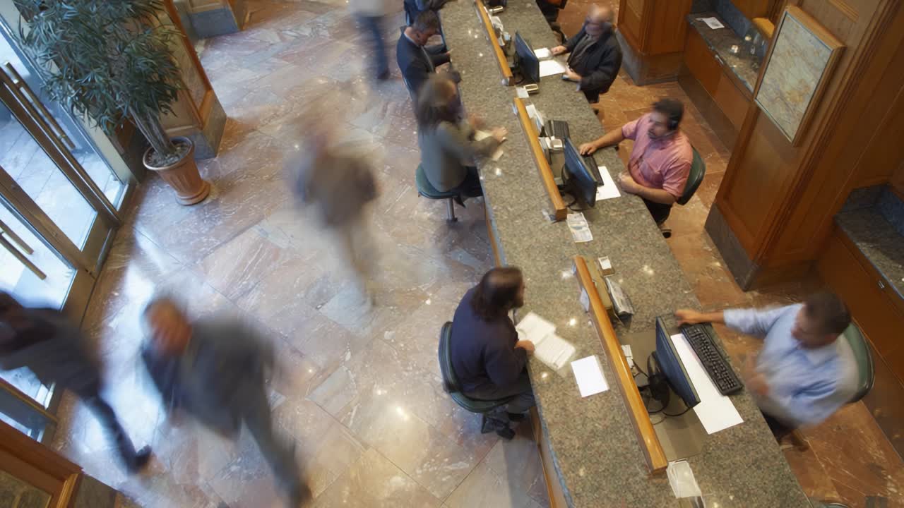 A Busy Lobby Scene: People Engaged in Transactions and Interactions at a Front Desk with Multiple Workstations and Lively Ambiance