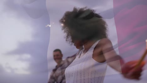 Animation-of-waving-flag-of-france-over-group-of-friend-having-fun-on-the-beach