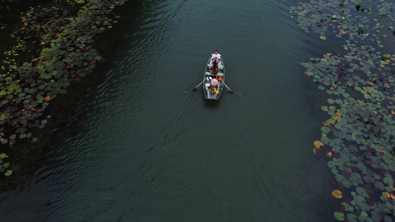 On a Sampan we float, through waters serene, past vegetation so green
