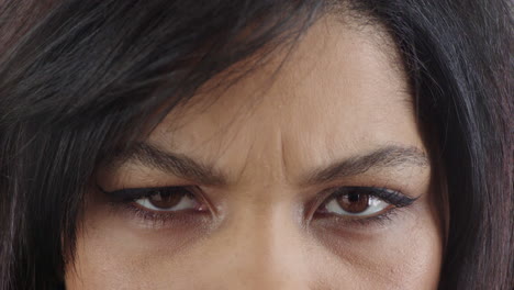 close up spaanse vrouw ogen fronsen kijken boze uitdrukking het dragen van make-up cosmetica vrouwelijke beaten