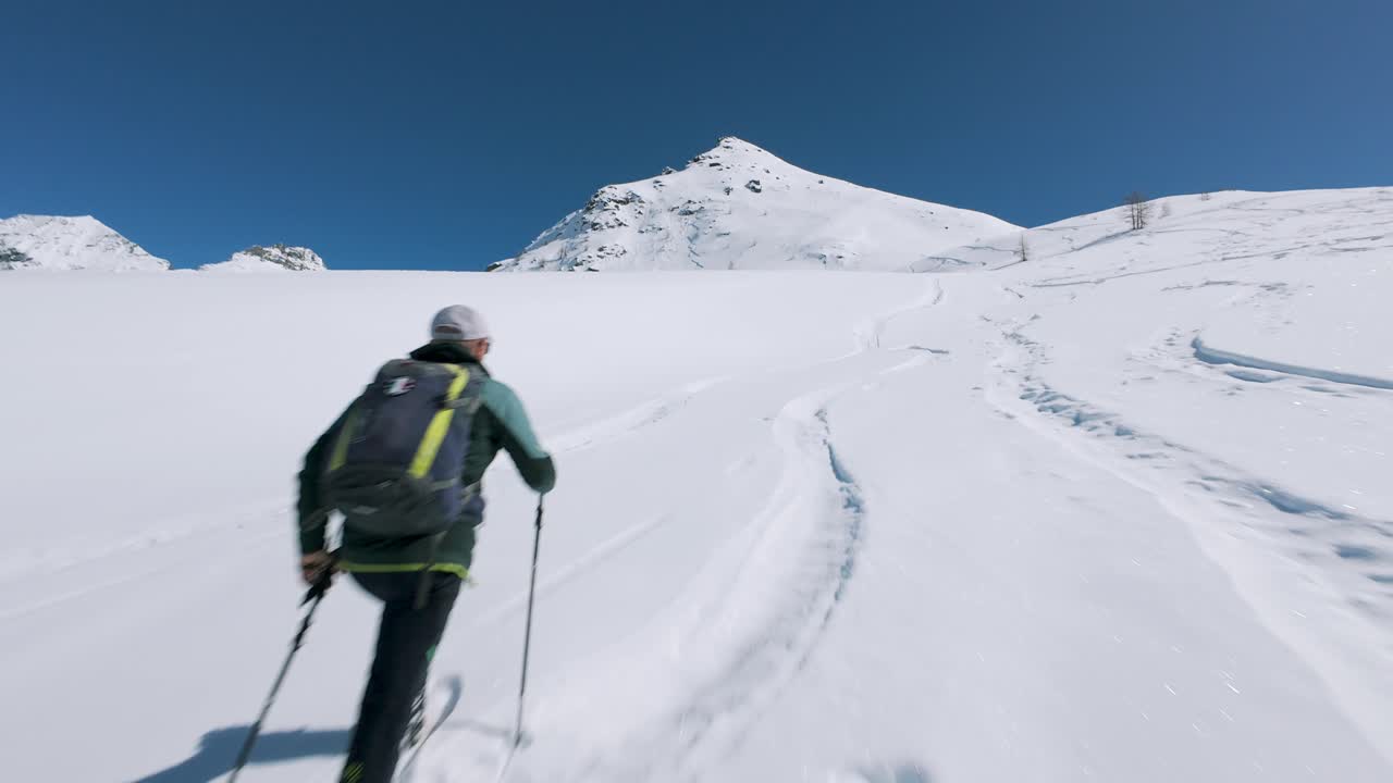 Ski Mountaineer Climbing On Snowy Slope In Cheneil, Italy. FPV drone shot