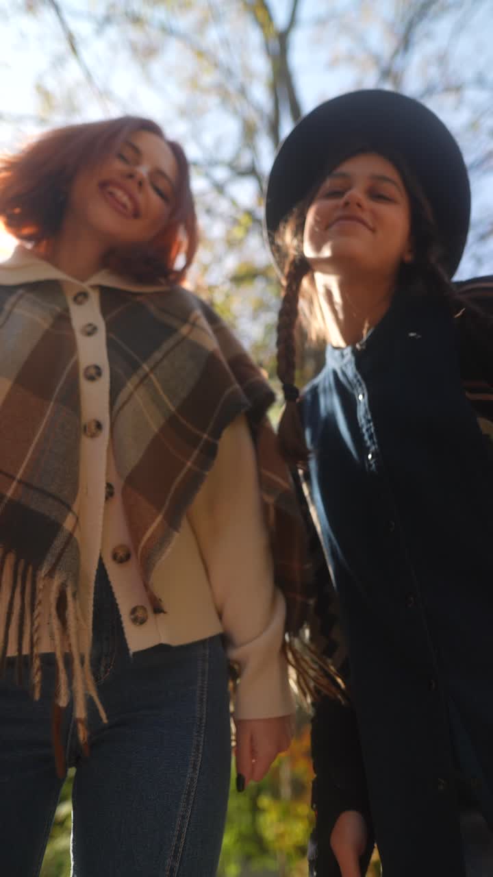 dos mujeres jóvenes disfrutando del follaje de otoño