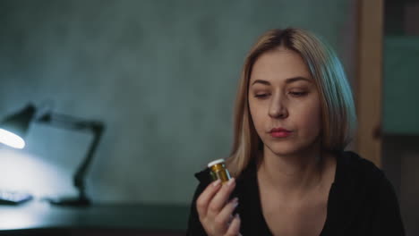 mujer pensativa gira botella de droga con producto no registrado