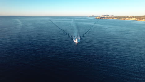 a luxury yacht cruising along a tropical coastline on a clear day - aerial view