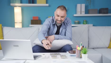 happy man calculating income and expense at home.