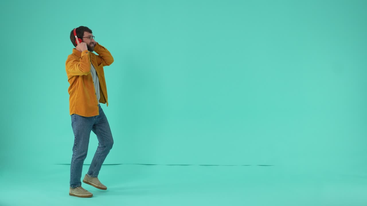 Bearded man wearing headphones dancing to music