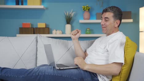 el hombre que mira la computadora portátil se alegra.