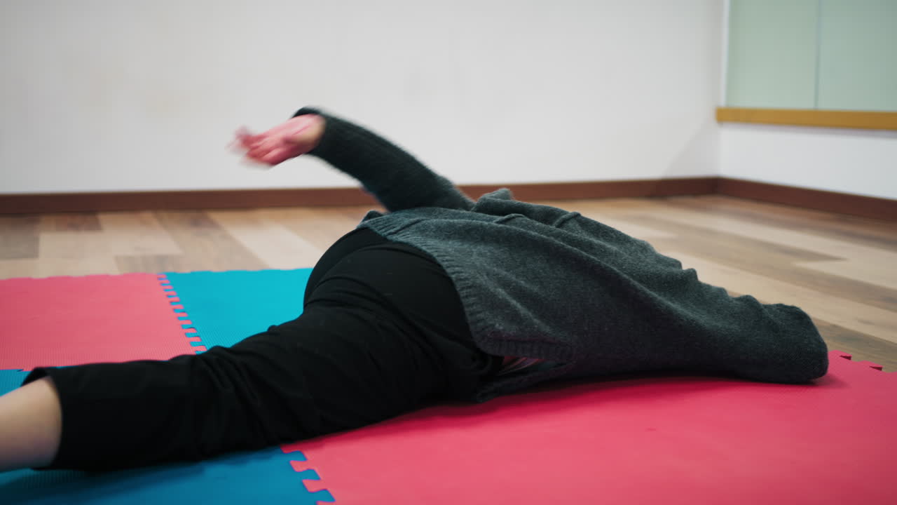On the Tatami of a Dance School a Woman Does Stretching Pre-Dance Exercises
