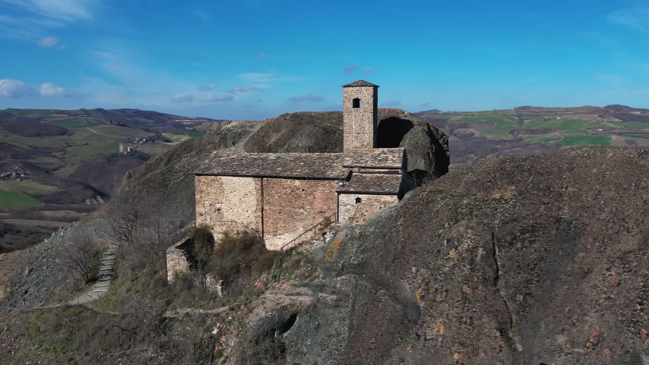 imágenes aéreas de pietra perduca, roca volcánica, iglesia situada en la piedra superior inmersa en el paisaje rural, tierra cultivada en val trebbia bobbio, emilia romagna, italia