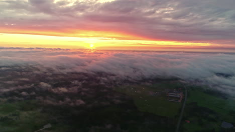 aerial of vivid sunset between two cloud layers - cloud inversion over landscape