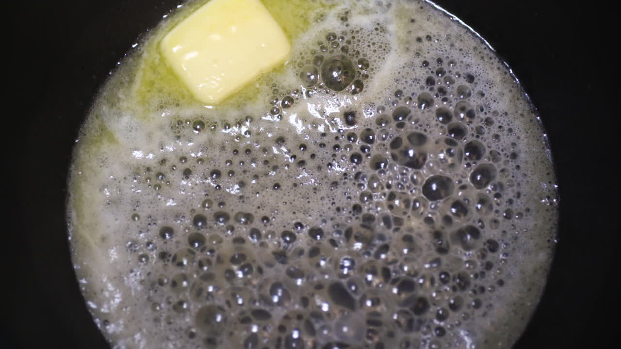 끓는 검은 냄비에 녹는 버터 - 요리