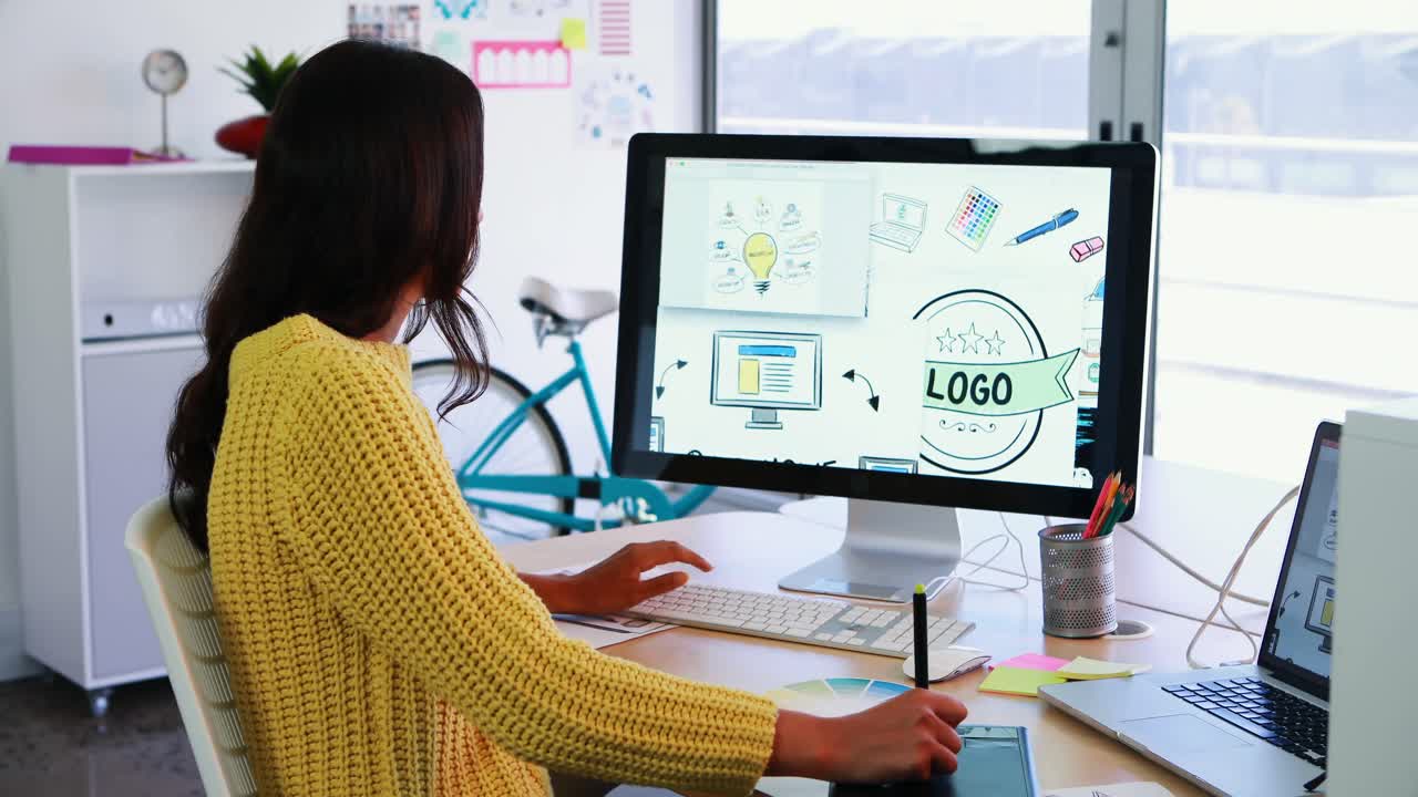 ejecutivo creativo utilizando una tableta gráfica mientras trabaja en una computadora de escritorio 4k