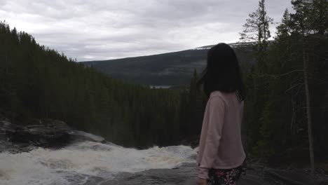 Niña-Mirando-Una-Cascada-En-El-Bosque